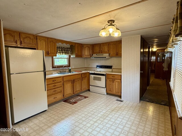 25 Wolfe Rd, Nescopeck, PA 18635 - kitchen with white appliances, under cabinet range hood, light flooring, light countertops, and brown cabinetry