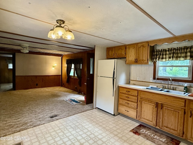 25 Wolfe Rd, Nescopeck, PA 18635 - kitchen featuring freestanding refrigerator, wood walls, light flooring, brown cabinets, and light countertops