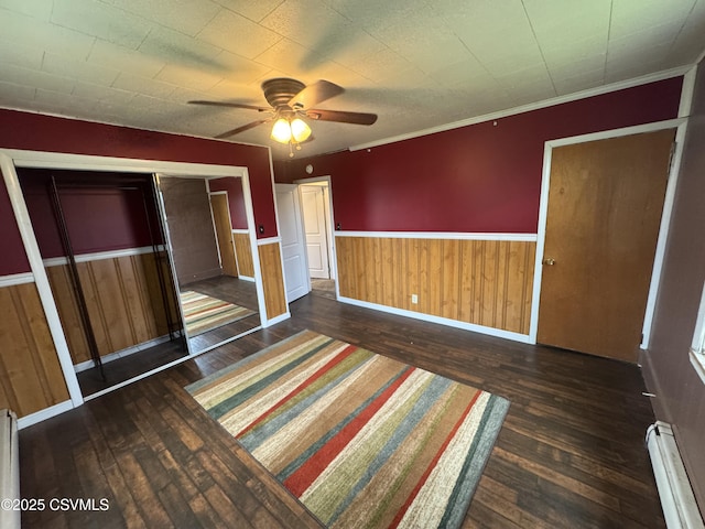 1715 Spring Garden Ave, Berwick, PA 18603 - unfurnished bedroom featuring dark wood finished floors, a baseboard radiator, wainscoting, and ceiling fan