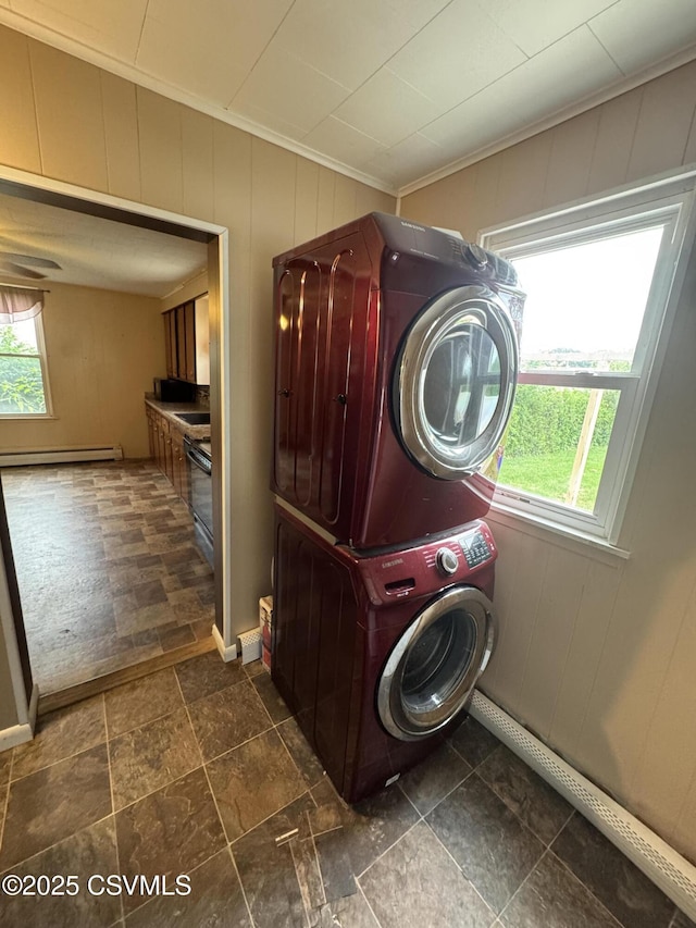 1715 Spring Garden Ave, Berwick, PA 18603 - washroom with baseboard heating, stacked washer / drying machine, ornamental molding, and dark stone finish flooring