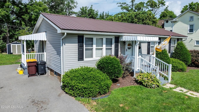 745 Liberty St, Danville, PA 17821 - view of front of house with a storage unit, a metal roof, and a front lawn