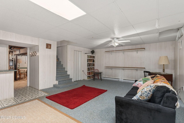 725 Avenue Ave E, Danville, PA 17821 - living area featuring a paneled ceiling, carpet flooring, a baseboard heating unit, stairway, and wooden walls
