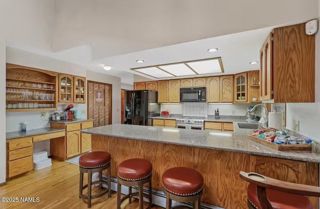 3120 W Tami Ln, Flagstaff, AZ 86001 - kitchen featuring black appliances, a peninsula, open shelves, a sink, and glass insert cabinets