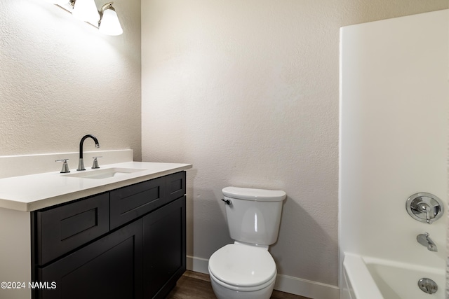 bathroom with toilet, vanity, and a bath