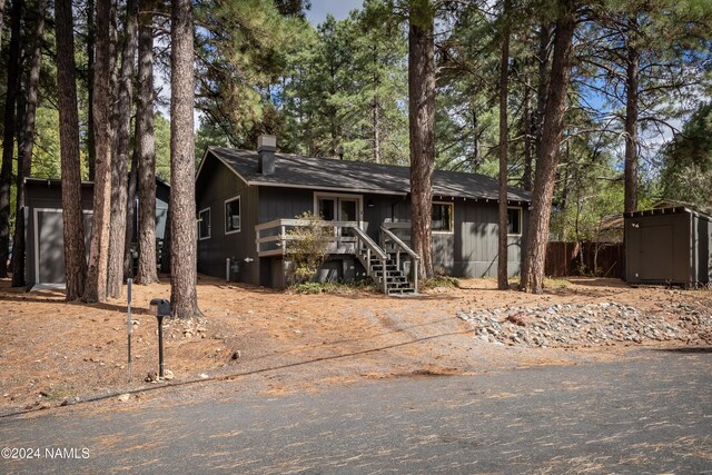 view of front of property with a wooden deck and a storage unit