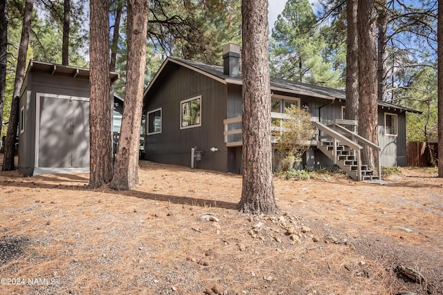 view of front of property featuring a shed