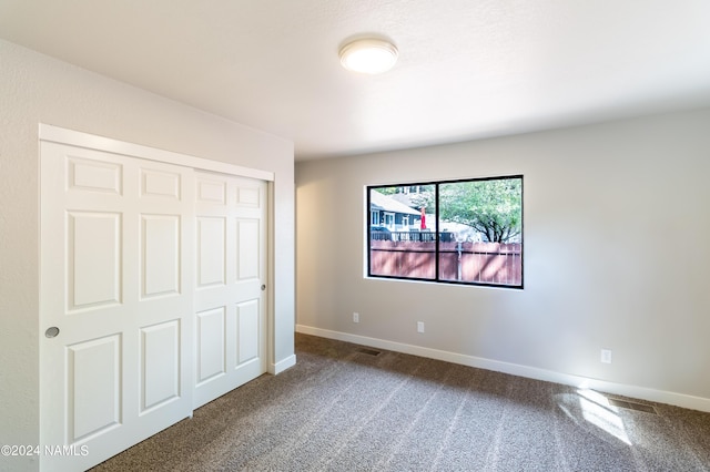 unfurnished bedroom with carpet flooring and a closet