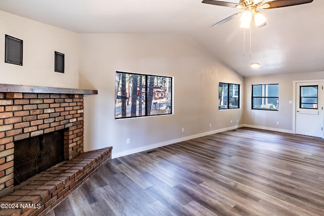 unfurnished living room featuring a brick fireplace, dark hardwood / wood-style flooring, lofted ceiling, and ceiling fan