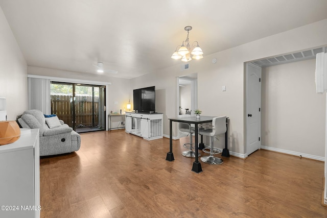 living room with hardwood / wood-style flooring and a notable chandelier