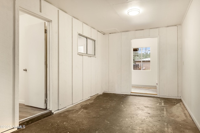 unfurnished room featuring wood walls