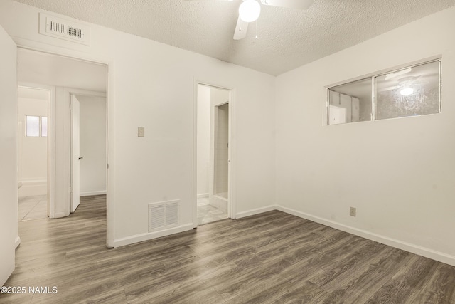 spare room featuring ceiling fan, dark wood-type flooring, and a textured ceiling