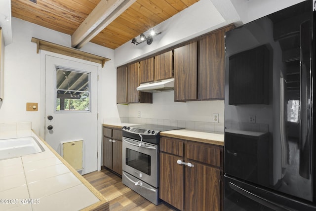 937 Osage, Flagstaff, AZ 86005 - kitchen with electric stove, tile counters, refrigerator, under cabinet range hood, and light wood finished floors