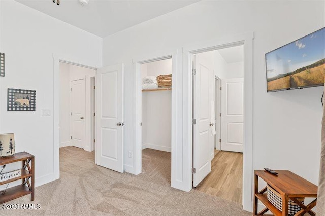 hallway featuring light colored carpet