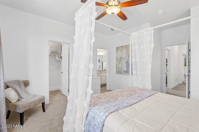 carpeted bedroom with ceiling fan, connected bathroom, a closet, and a walk in closet