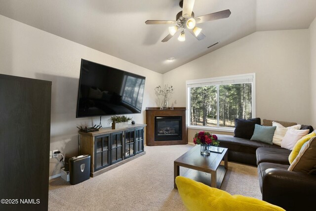 4435 E Savannah Cir, Flagstaff, AZ 86004 - carpeted living room with visible vents, a ceiling fan, vaulted ceiling, and a glass covered fireplace