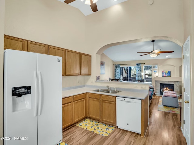 kitchen featuring sink, white appliances, ceiling fan, light hardwood / wood-style floors, and kitchen peninsula