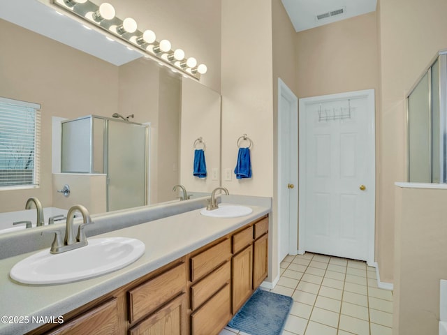 bathroom featuring walk in shower, vanity, and tile patterned flooring