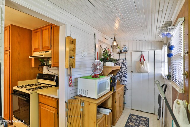 kitchen featuring white appliances and wood walls