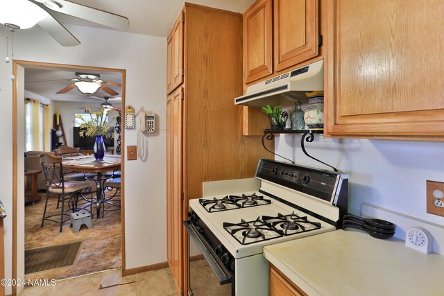 kitchen featuring ceiling fan, light tile patterned floors, and white range with gas cooktop