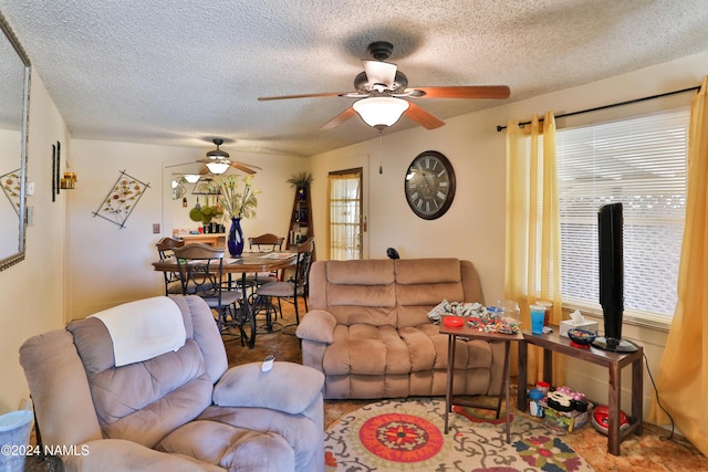 living room featuring a textured ceiling and ceiling fan