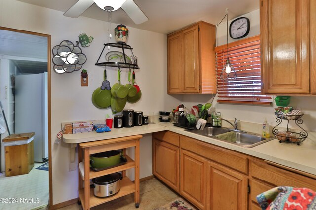 kitchen featuring pendant lighting, ceiling fan, sink, light tile patterned flooring, and refrigerator