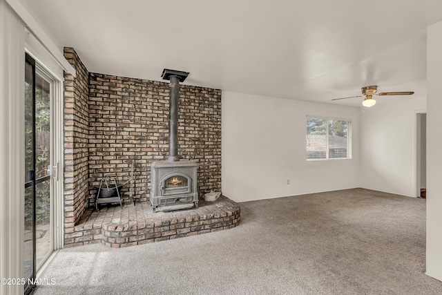 3494 N Andes Dr, Flagstaff, AZ 86004 - unfurnished living room featuring a wood stove, carpet flooring, and a ceiling fan
