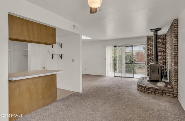 3494 N Andes Dr, Flagstaff, AZ 86004 - living room with light carpet, a wood stove, and light tile patterned floors