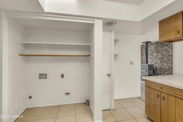 3494 N Andes Dr, Flagstaff, AZ 86004 - laundry room with electric dryer hookup, washer hookup, gas dryer hookup, a wood stove, and light tile patterned flooring
