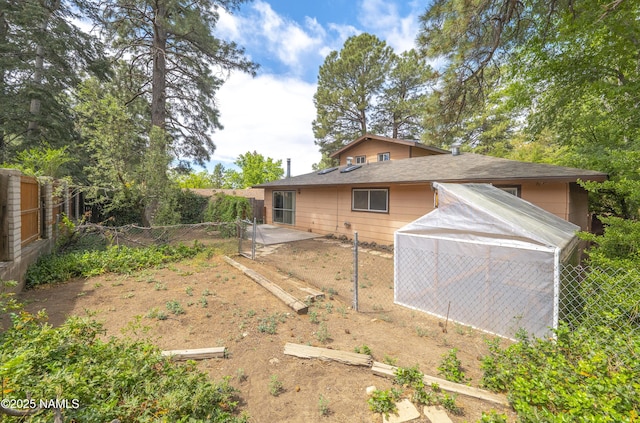 3494 N Andes Dr, Flagstaff, AZ 86004 - fenced yard featuring a greenhouse, an outdoor structure, and a patio area