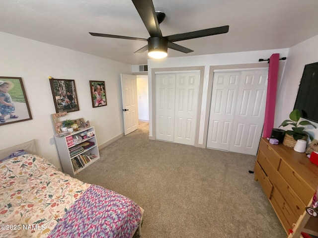 carpeted bedroom with multiple closets and ceiling fan