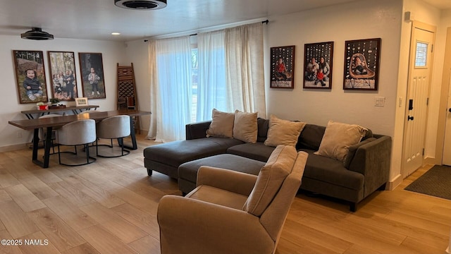 living area featuring light wood-style floors and baseboards