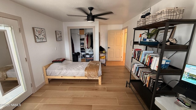 bedroom featuring wood tiled floors, baseboards, a closet, and a ceiling fan