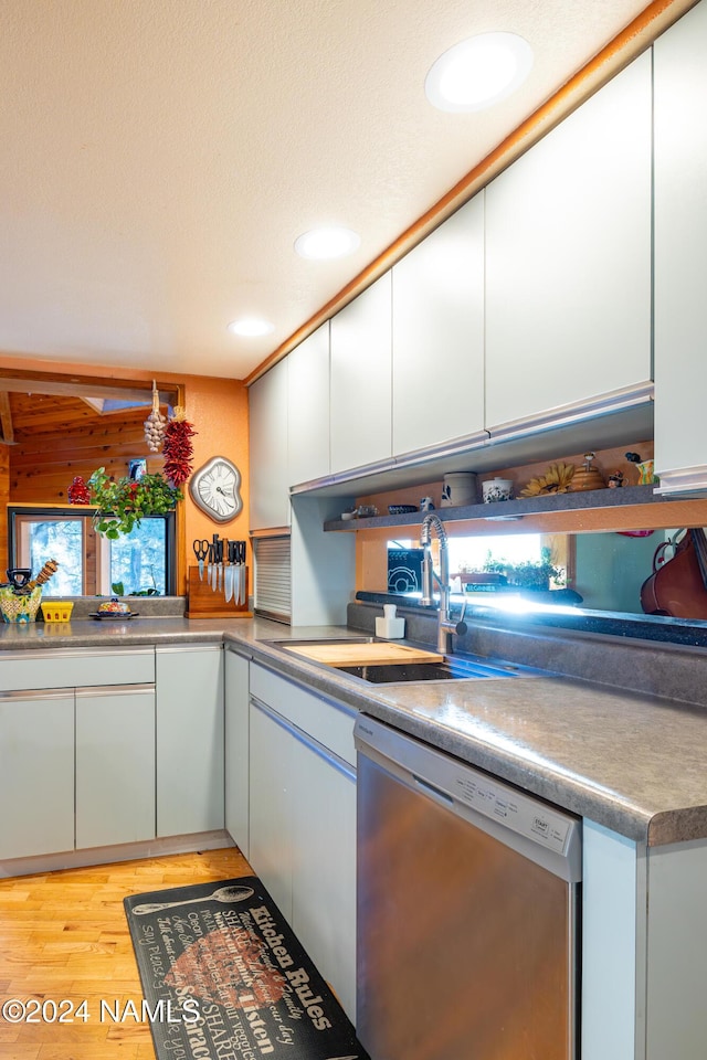 kitchen with sink, light hardwood / wood-style flooring, dishwasher, and white cabinetry