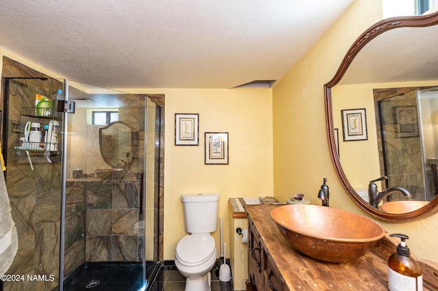 bathroom with a textured ceiling, toilet, tile patterned flooring, and a shower with shower door