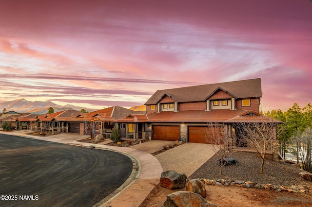 view of front of home with board and batten siding, stone siding, and decorative driveway