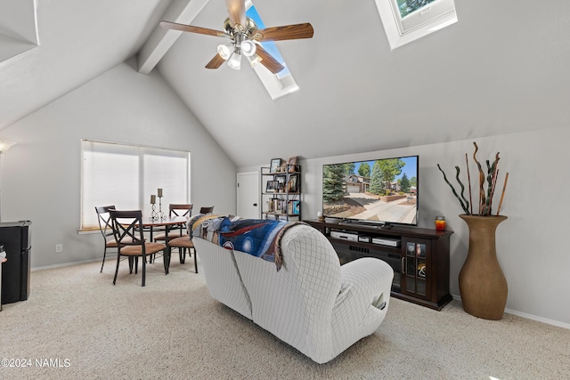 living room featuring ceiling fan, lofted ceiling with skylight, and light colored carpet