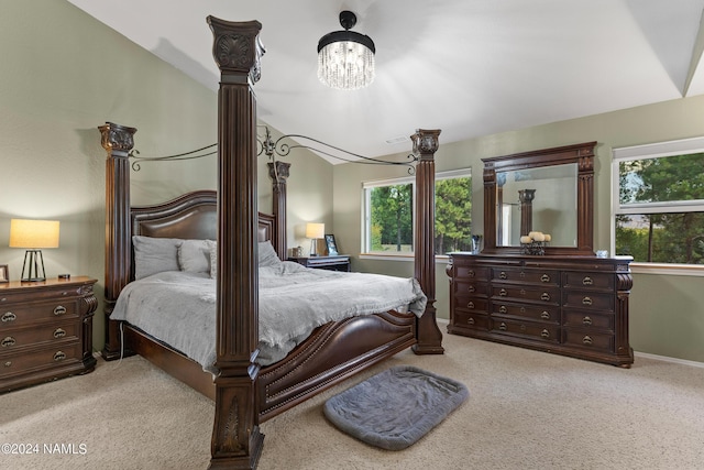 bedroom with light colored carpet, multiple windows, a notable chandelier, and vaulted ceiling