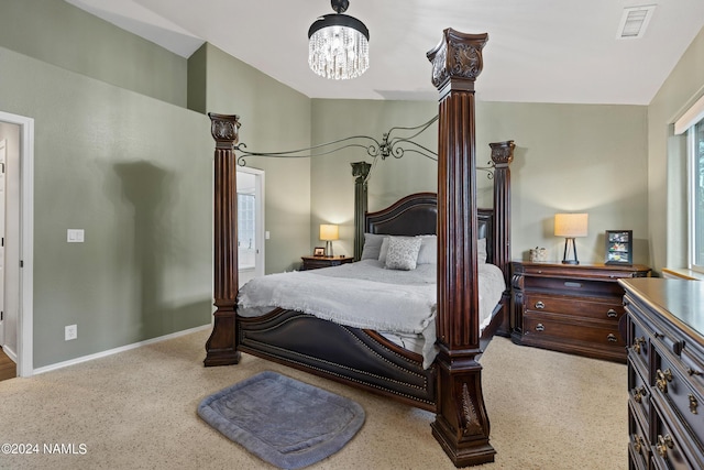 carpeted bedroom featuring vaulted ceiling and an inviting chandelier