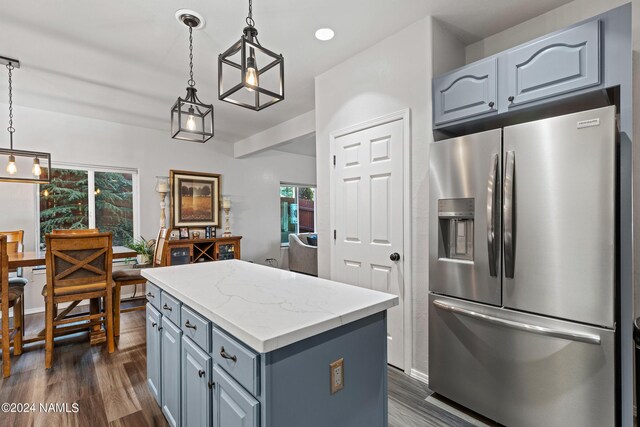 kitchen featuring decorative light fixtures, dark wood-type flooring, stainless steel fridge with ice dispenser, and a center island