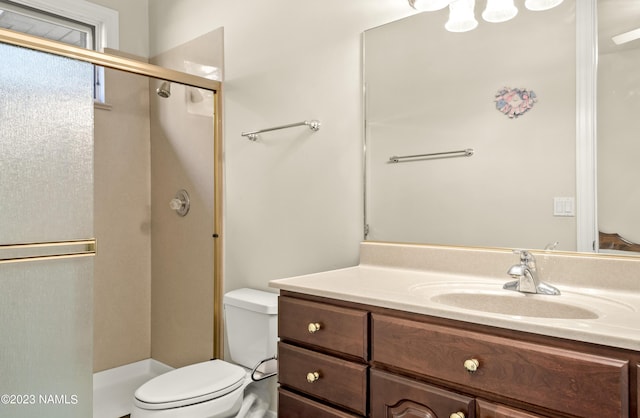 bathroom featuring vanity, toilet, and an enclosed shower