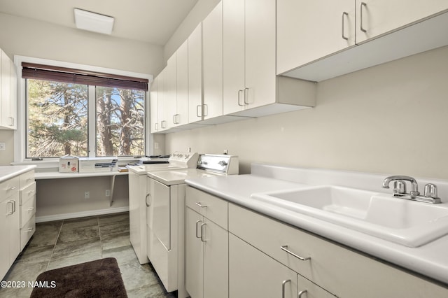 washroom featuring cabinets, separate washer and dryer, and sink