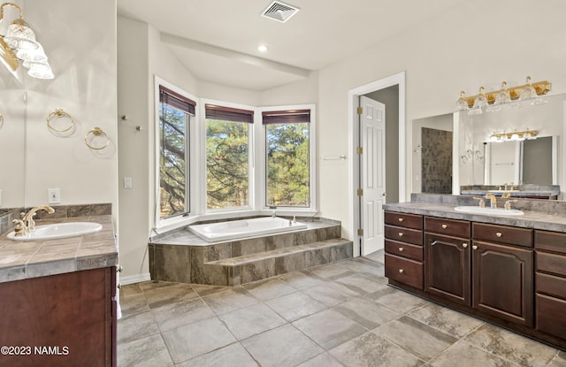 bathroom featuring tiled bath and vanity