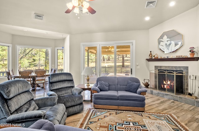 living room with hardwood / wood-style flooring, ceiling fan, and a fireplace