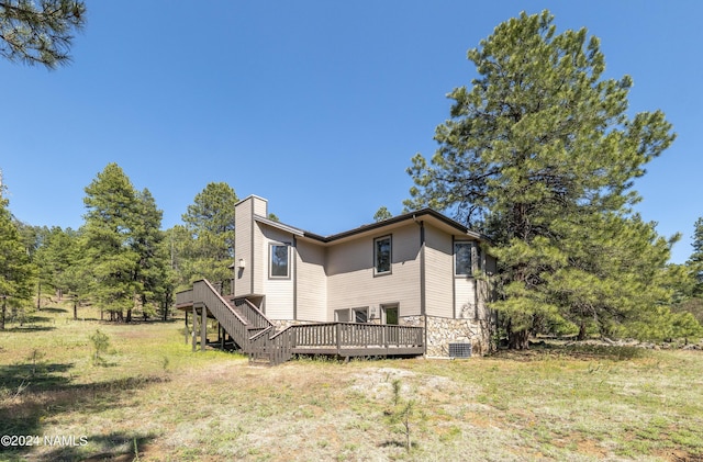 view of side of home with a deck and a yard