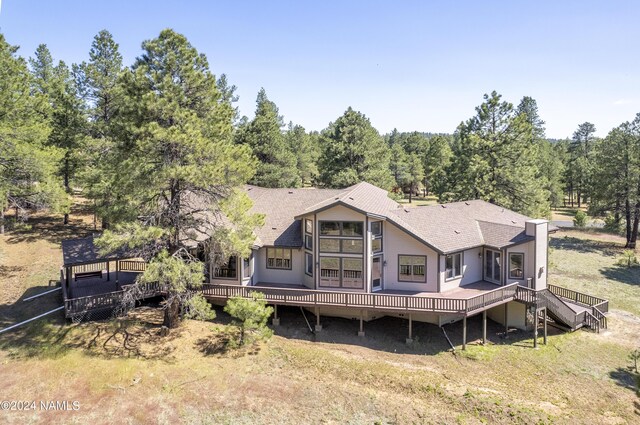 back of property with a lawn and a deck