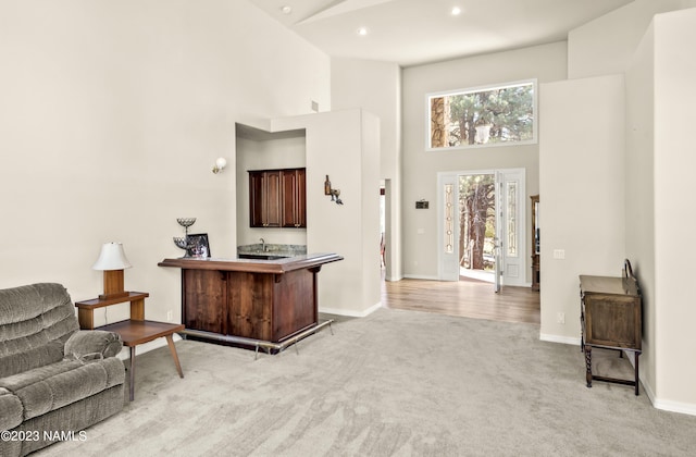 carpeted living room featuring a towering ceiling