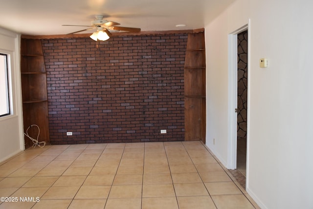 644 W Hillview St, Winslow, AZ 86047 - empty room with brick wall, ceiling fan, and light tile patterned floors