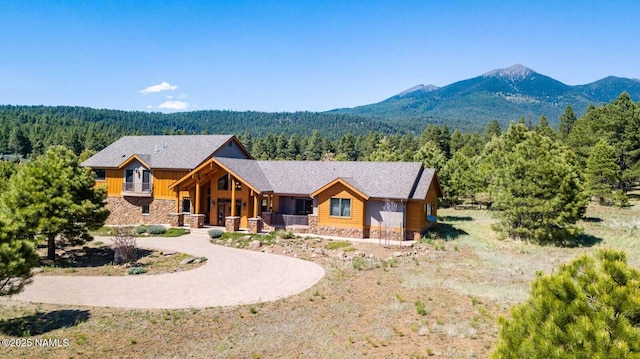 9178 N Snowbowl Ranch Rd, Flagstaff, AZ 86001 - view of front facade featuring stone siding, a wooded view, a mountain view, and a chimney