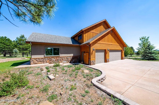 9178 N Snowbowl Ranch Rd, Flagstaff, AZ 86001 - view of front of home featuring stone siding, board and batten siding, driveway, an attached garage, and stucco siding