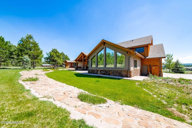 9178 N Snowbowl Ranch Rd, Flagstaff, AZ 86001 - back of house with stone siding, a yard, and an attached garage